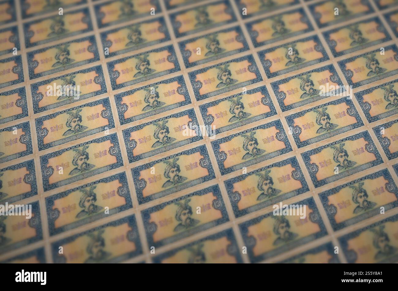 5 banconote ucraine di hryvnias stampate in un trasportatore di produzione di denaro illegale. Collage di molte banconote false. Concetto di lavoro di massa dei contraffattori. 5 Foto Stock