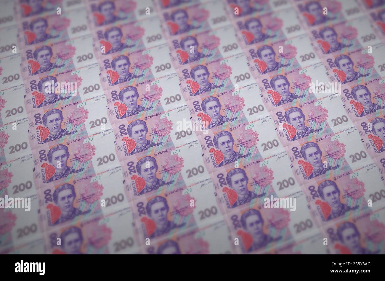 200 banconote ucraine di hryvnias stampate in un trasportatore di produzione di denaro illegale. Collage di molte banconote false. Concetto di lavoro di massa dei contraffattori. 200 Foto Stock