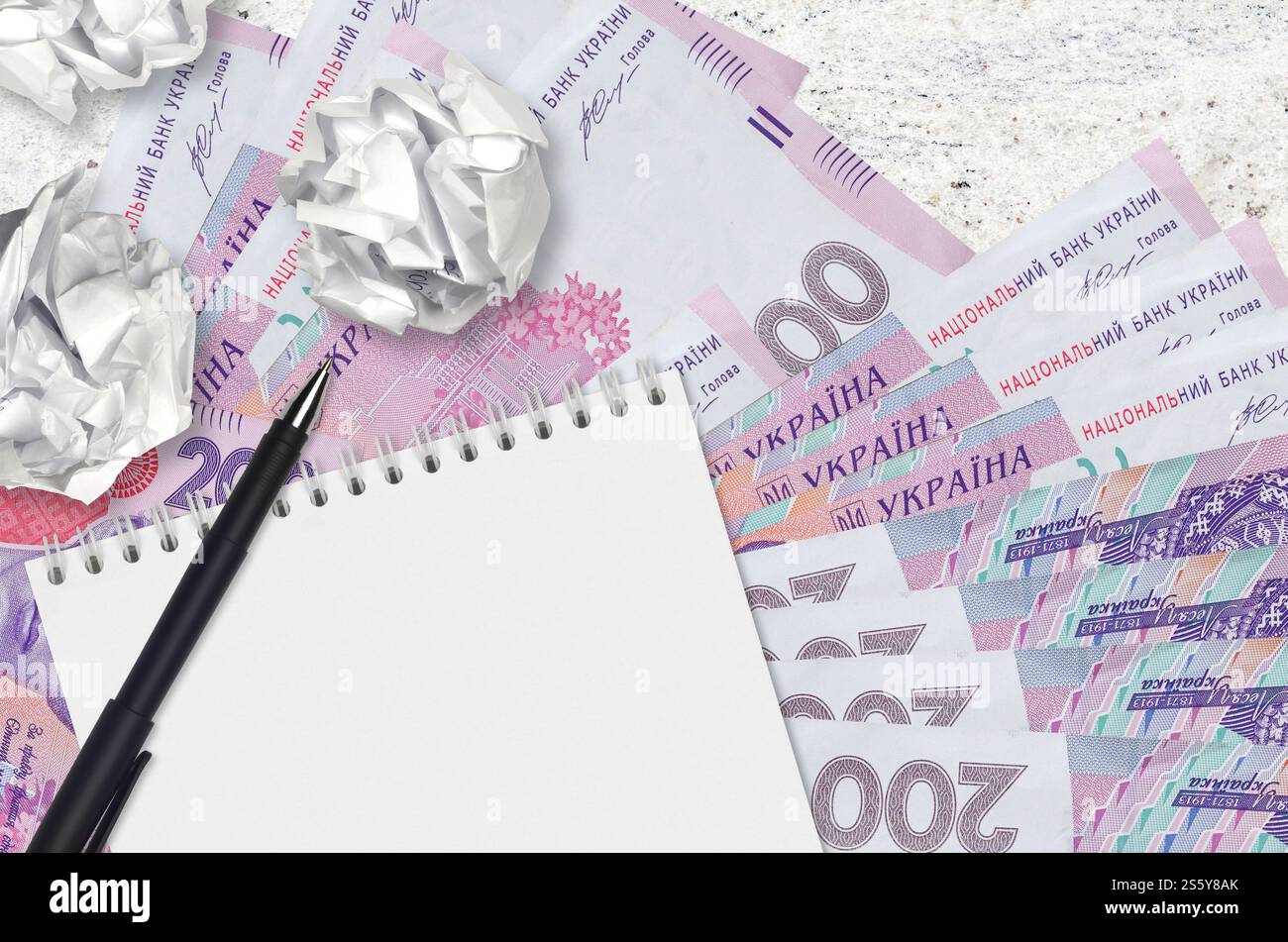 200 hryvnias ucraine banconote e palle di carta stropicciata con blocco note. Idee cattive o meno di concetto di ispirazione. Alla ricerca di idee per l'investimento. 200 Foto Stock