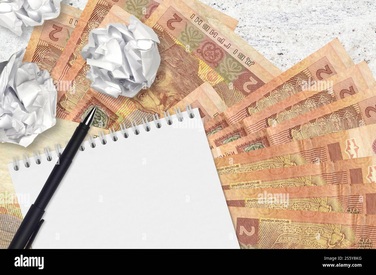 2 banconote e palle di hryvnias ucraine di carta stropicciata con blocco note. Idee cattive o meno di concetto di ispirazione. Alla ricerca di idee per l'investimento. 2 Foto Stock