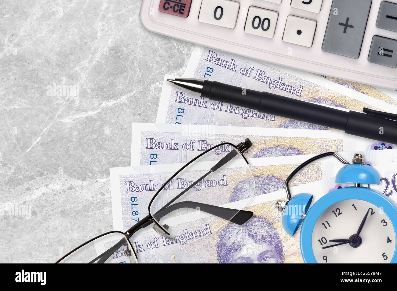 Banconote da 20 sterline britanniche e calcolatrice con occhiali e penna. Concetto di stagione del prestito aziendale o del pagamento delle imposte. Pianificazione finanziaria e tempo per pagare le tasse. Foto Stock