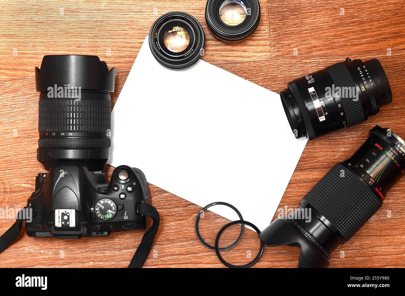 Kit completo per la moderna fotocamera digitale reflex e il foglio di carta bianca per copyspace. Il concetto di apprendimento della fotografia. Coperchio per mostre fotografiche, Foto Stock