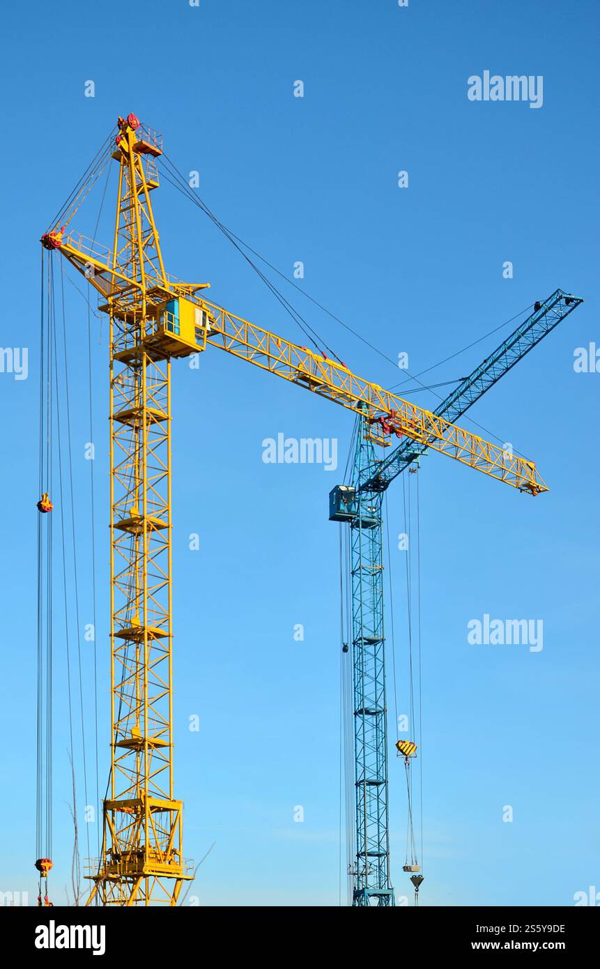 Sfondo industriale astratto con gru a torre da costruzione su un cielo blu chiaro. Cantiere. Edificio in fase di costruzione con Foto Stock
