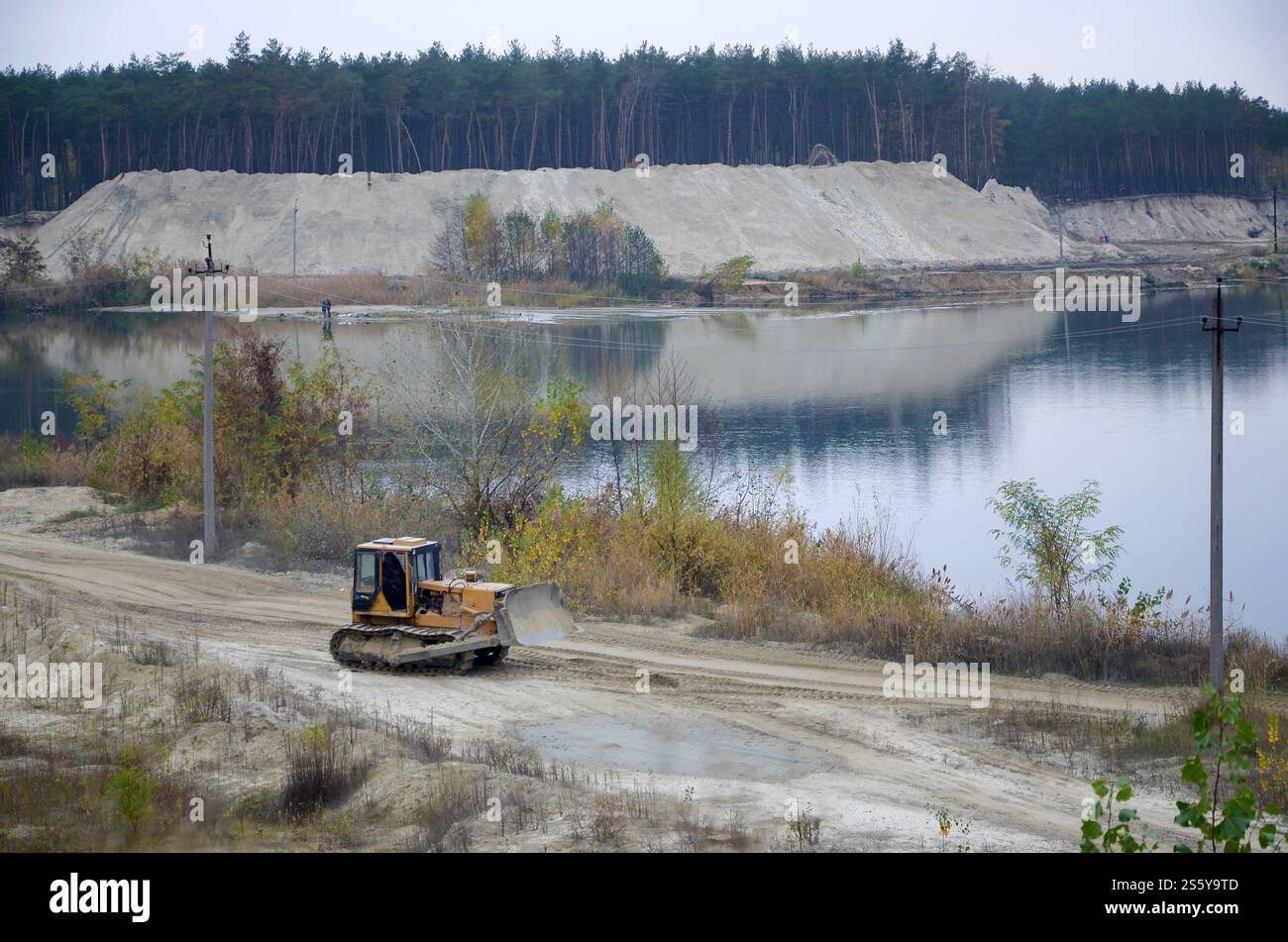 Aggregato da cava con macchinari per impieghi gravosi nel settore delle costruzioni. Escavatore pala Caterpillar con retroescavatore per la cava del cantiere. Foto Stock