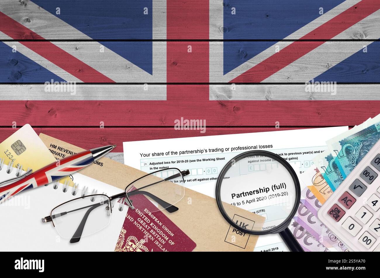 Modulo fiscale inglese sa104 Partnership di HM revenue and Customs si trova sul tavolo con gli articoli per ufficio. Documentazione HMRC e processo di pagamento delle tasse in United Foto Stock