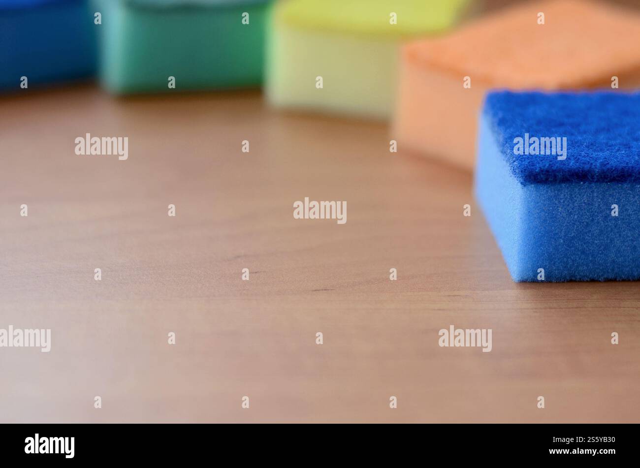 Un paio di spugne cucina giacciono su una cucina in legno il ripiano del bancone. Gli oggetti colorati per il lavaggio di stoviglie e pulizia in casa sono pronto per l'uso Foto Stock