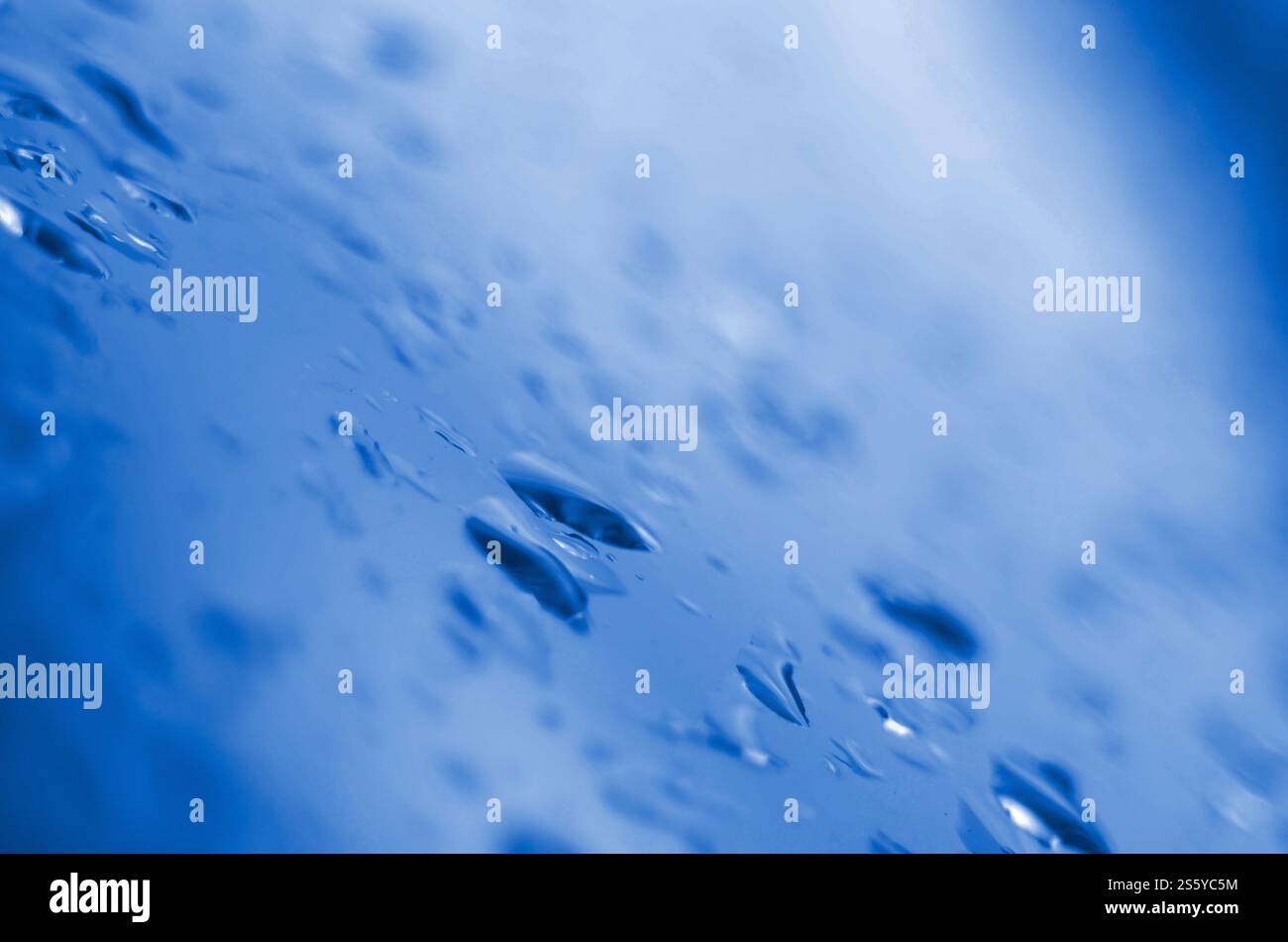 Piccole gocce di pioggia d'acqua sul vetro blu in macro. Sfondo naturale astratto, classico colore blu fantoccio. Gocce d'acqua, gocce di pioggia. phantom classico blu Foto Stock