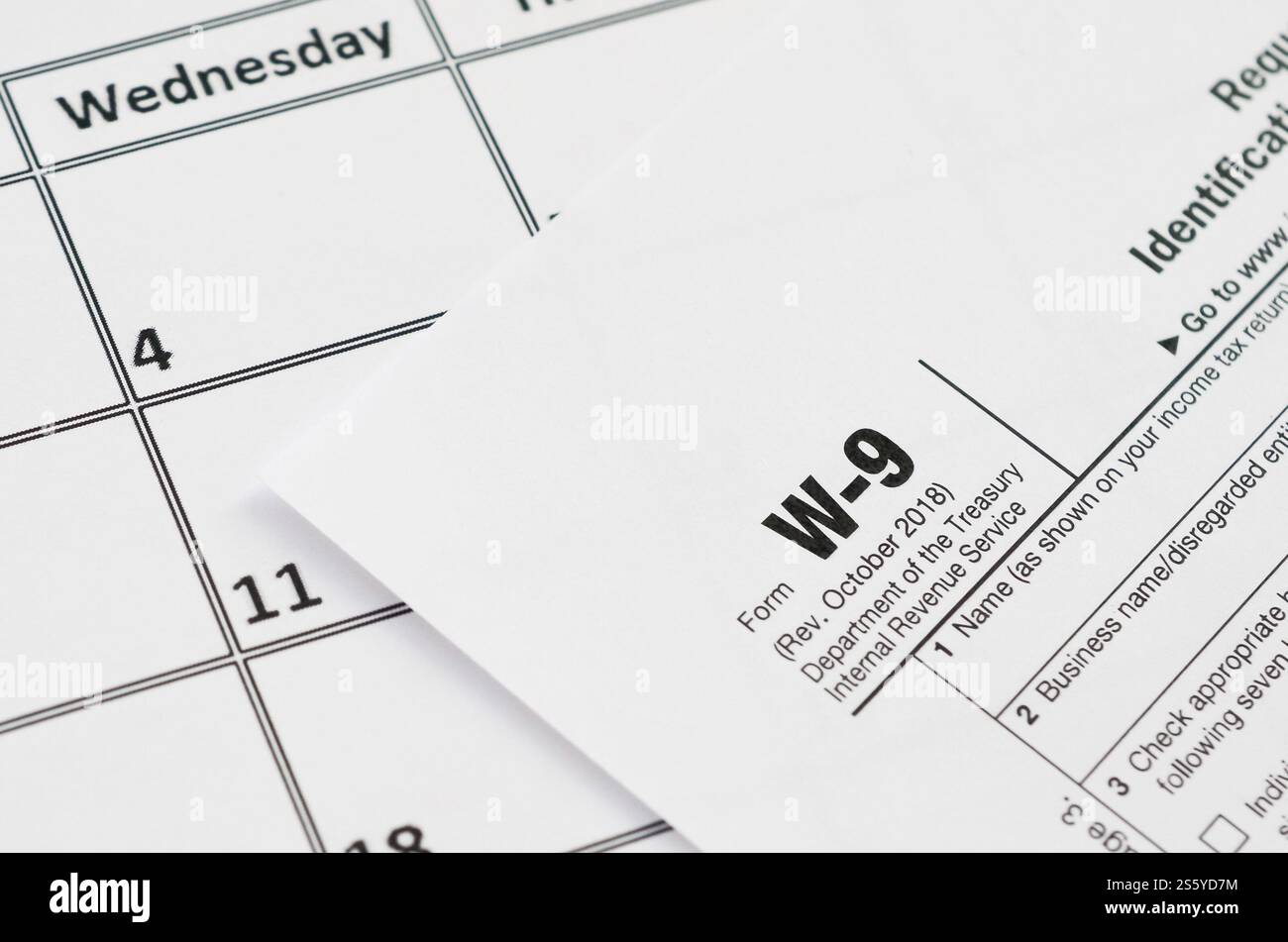 Il modulo IRS W-9 richiede il numero di identificazione del contribuente e il certificato vuoto si trova nella pagina vuota del calendario. Concetto del periodo fiscale. Copia spazio per il testo. Foto Stock