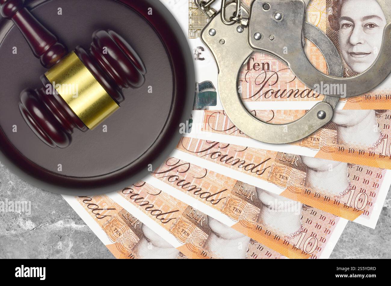 Banconote da 10 sterline britanniche e martello da giudice con manette della polizia sul banco del tribunale. Concetto di processo giudiziario o corruzione. Evasione fiscale o evasione fiscale. 10 Foto Stock