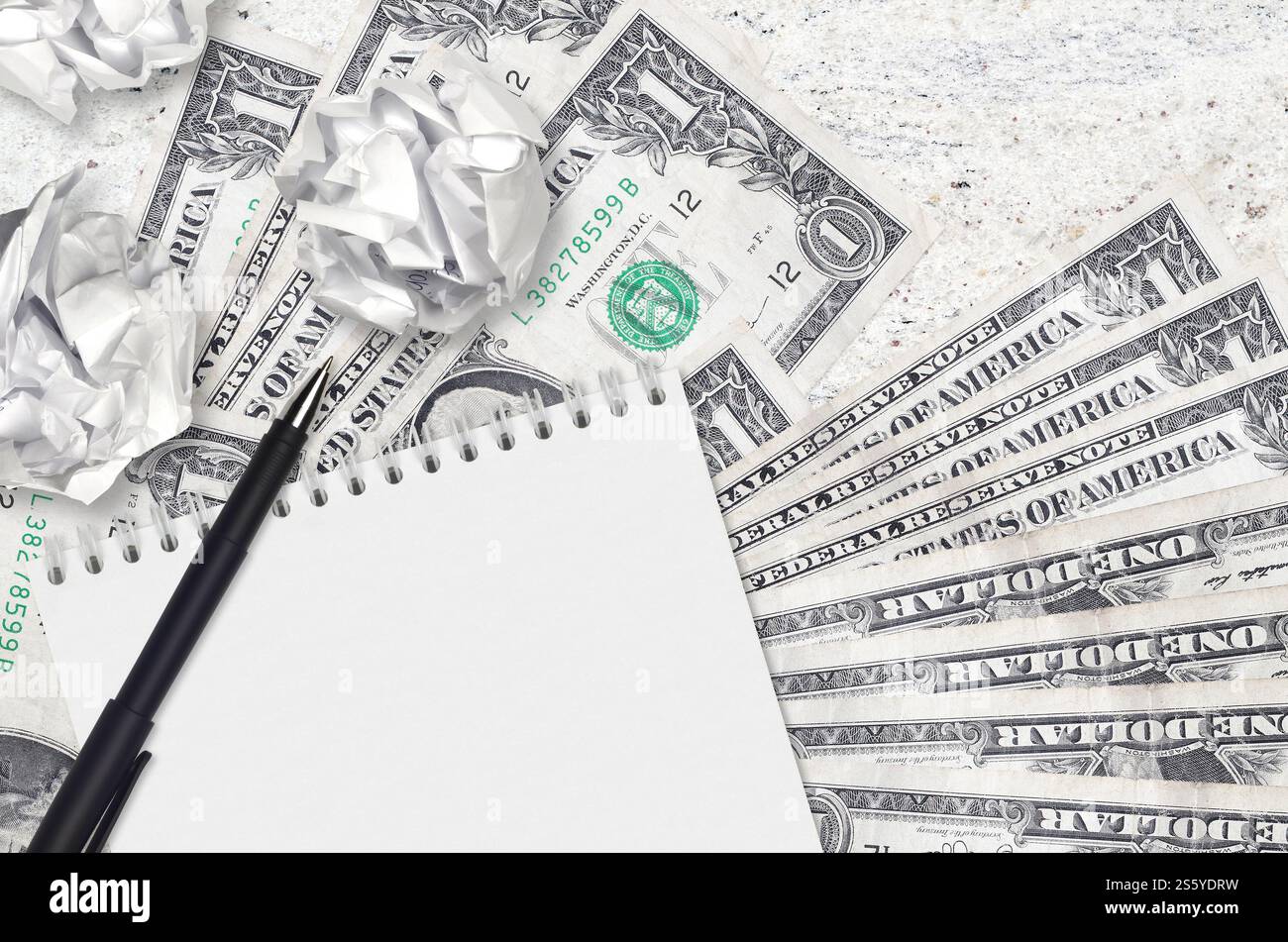 Banconote da 1 dollaro USA e palle di carta increspata con blocco note. Idee cattive o meno di concetto di ispirazione. Alla ricerca di idee per l'investimento. 1 dollaro USA Foto Stock