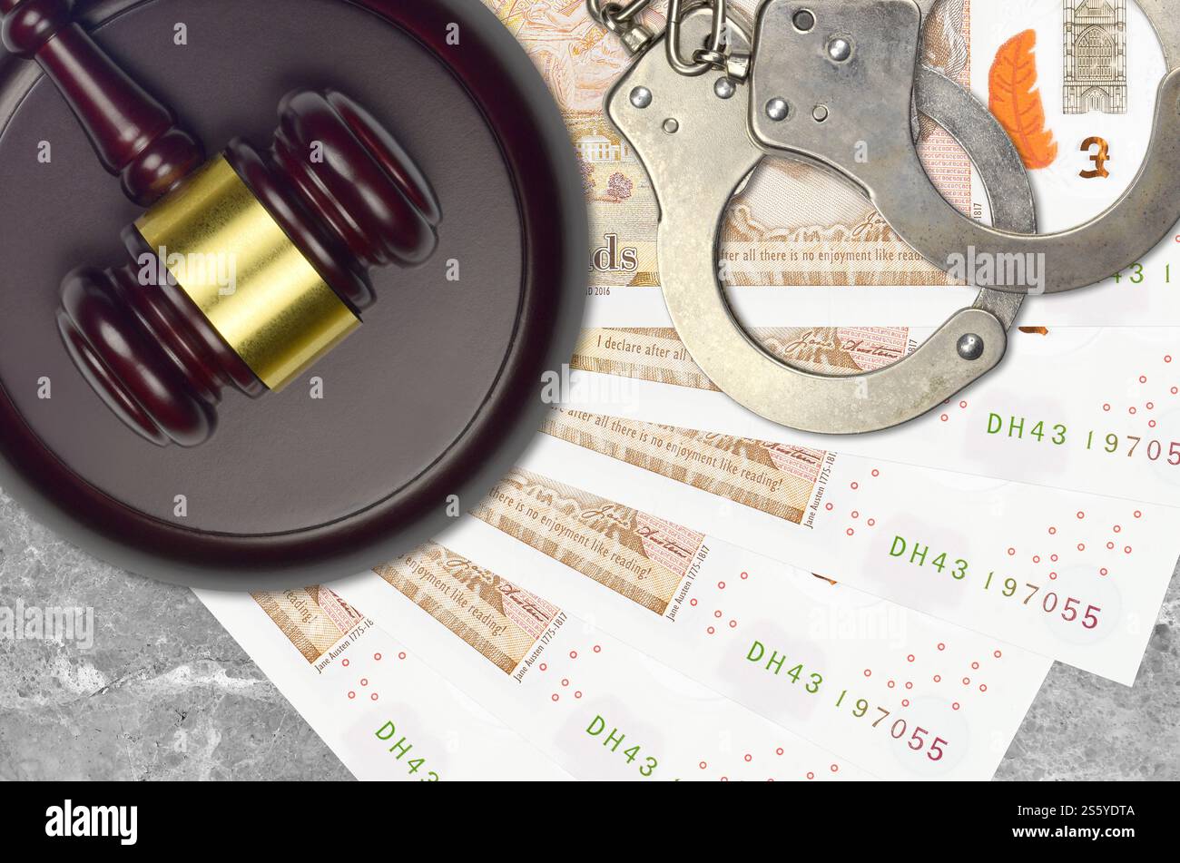 Banconote da 10 sterline britanniche e martello da giudice con manette della polizia sul banco del tribunale. Concetto di processo giudiziario o corruzione. Evasione fiscale o evasione fiscale. 10 Foto Stock