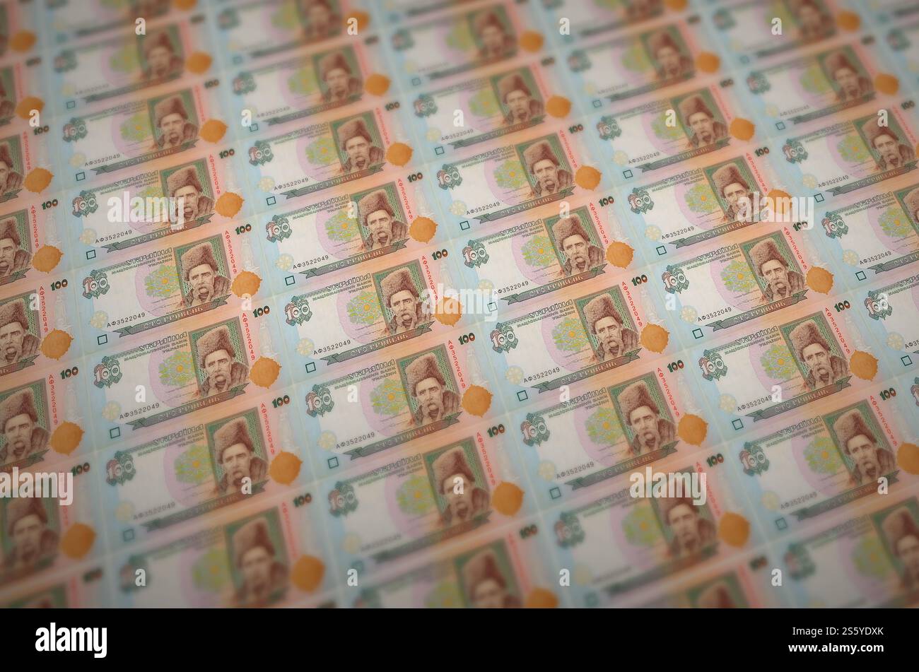 100 banconote ucraine di hryvnias stampate in un trasportatore di produzione di denaro illegale. Collage di molte banconote false. Concetto di lavoro di massa dei contraffattori. 100 Foto Stock