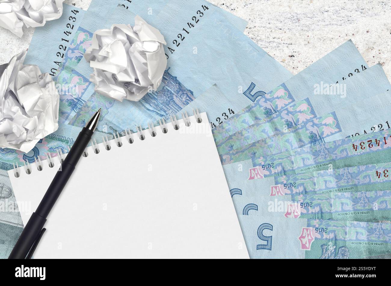 5 hryvnias ucraini banconote e palle di carta stropicciata con blocco note. Idee cattive o meno di concetto di ispirazione. Alla ricerca di idee per l'investimento. 5 Foto Stock