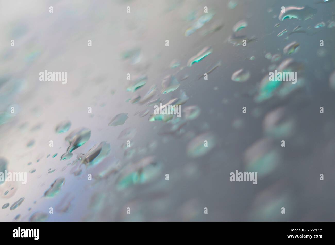 Acqua di piccole gocce di pioggia sul vetro blu nella macro. Natura astratta sfondo Foto Stock