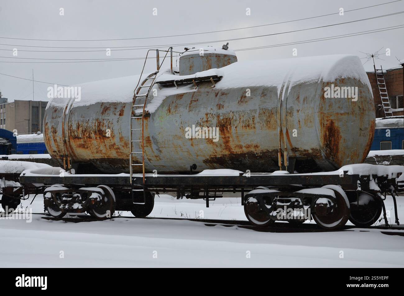 Foto dettagliate di snowy congelato il trasporto merci ferroviario auto. Un frammento di parti dei componenti del carro merci su ferrovia nel nevoso inverno sera Foto Stock