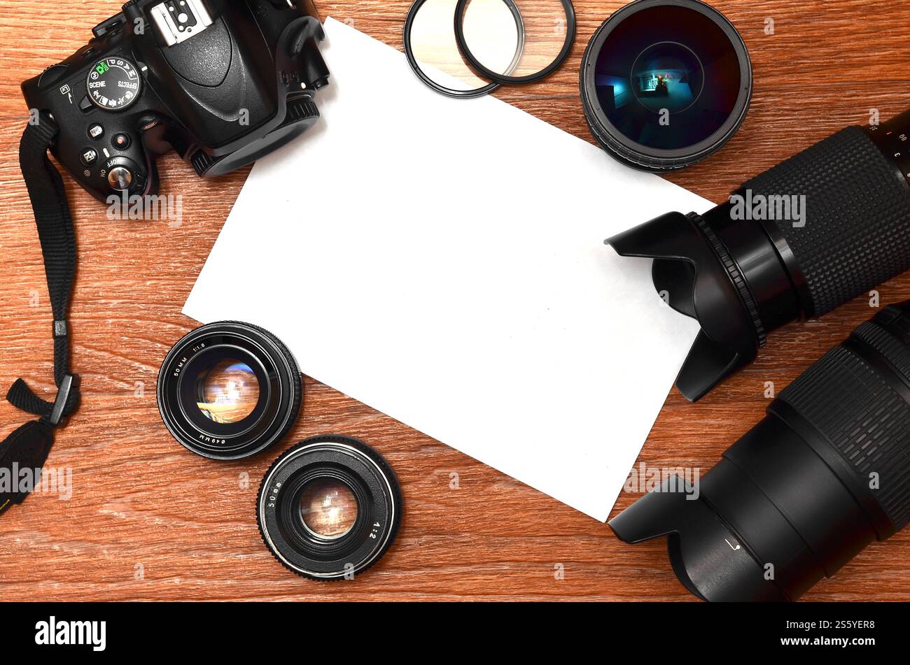 Kit completo per la moderna fotocamera digitale reflex e il foglio di carta bianca per copyspace. Il concetto di apprendimento della fotografia. Coperchio per mostre fotografiche, Foto Stock