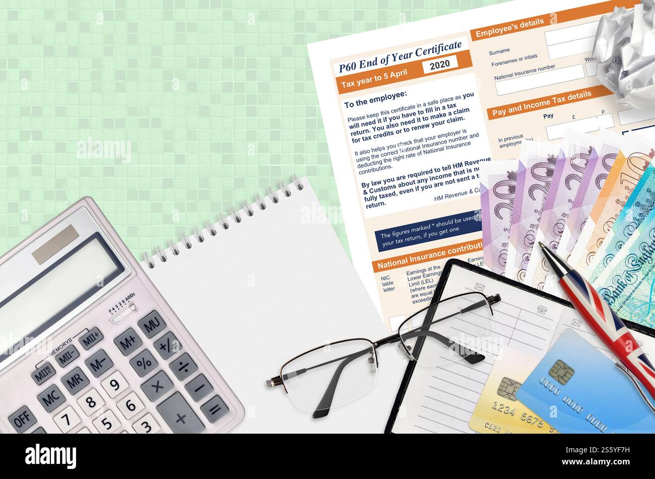 Modulo fiscale inglese P60 certificato di fine anno da HM Revenue and Customs si trova sul tavolo con gli articoli per ufficio. Documentazione HMRC e processo di pagamento delle imposte in Foto Stock