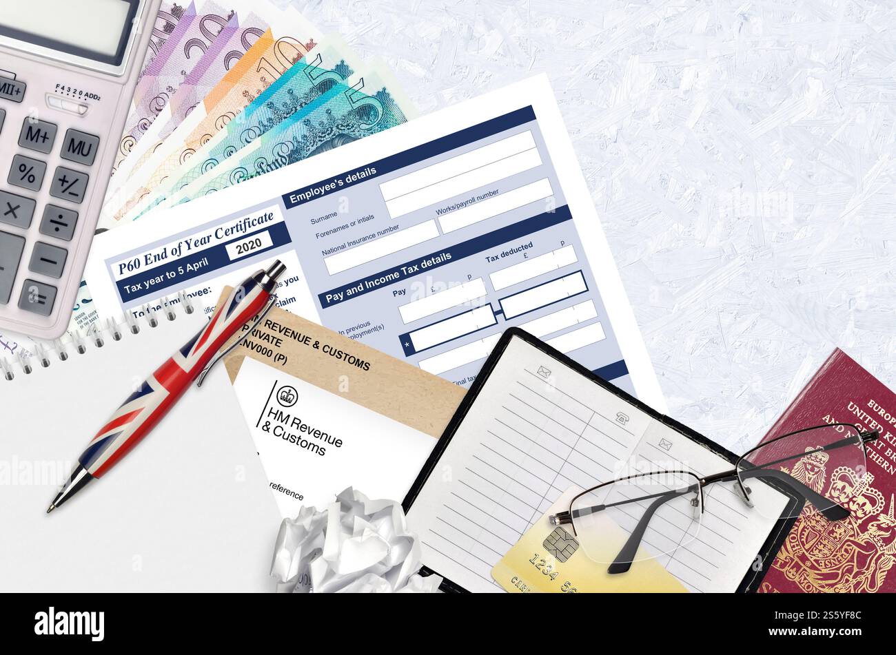 Modulo fiscale inglese P60 certificato di fine anno da HM Revenue and Customs si trova sul tavolo con gli articoli per ufficio. Documentazione HMRC e processo di pagamento delle imposte in Foto Stock