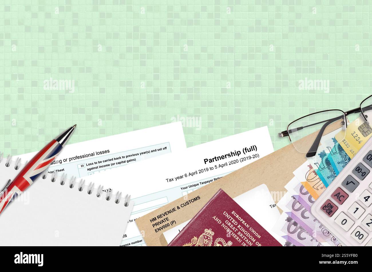 Modulo fiscale inglese sa104 Partnership di HM revenue and Customs si trova sul tavolo con gli articoli per ufficio. Documentazione HMRC e processo di pagamento delle tasse in United Foto Stock