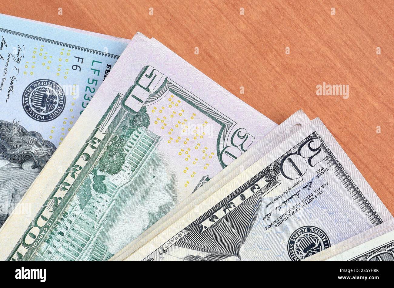 Pile di banconote da centocinquanta dollari su fondo in legno da vicino. Vista dall'alto in posizione piatta. Concetto di successo astratto o di business. Foto Stock