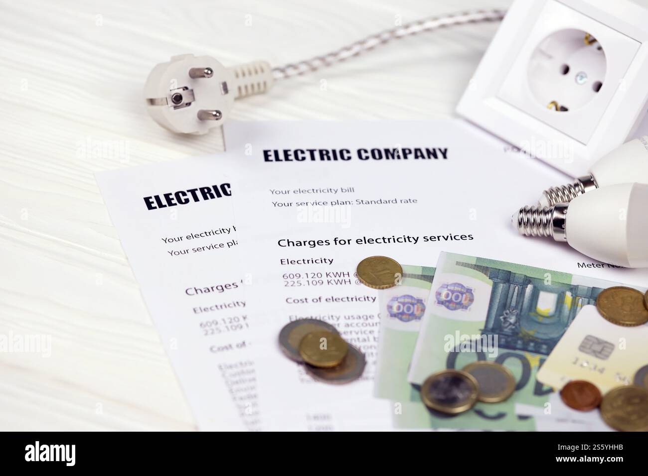 Calcolatrice e bollette Euro con penna sulla bolletta europea dell'elettricità. Concetto di risparmio economico utilizzando lampadine a LED a risparmio energetico e bolletta elettrica Foto Stock