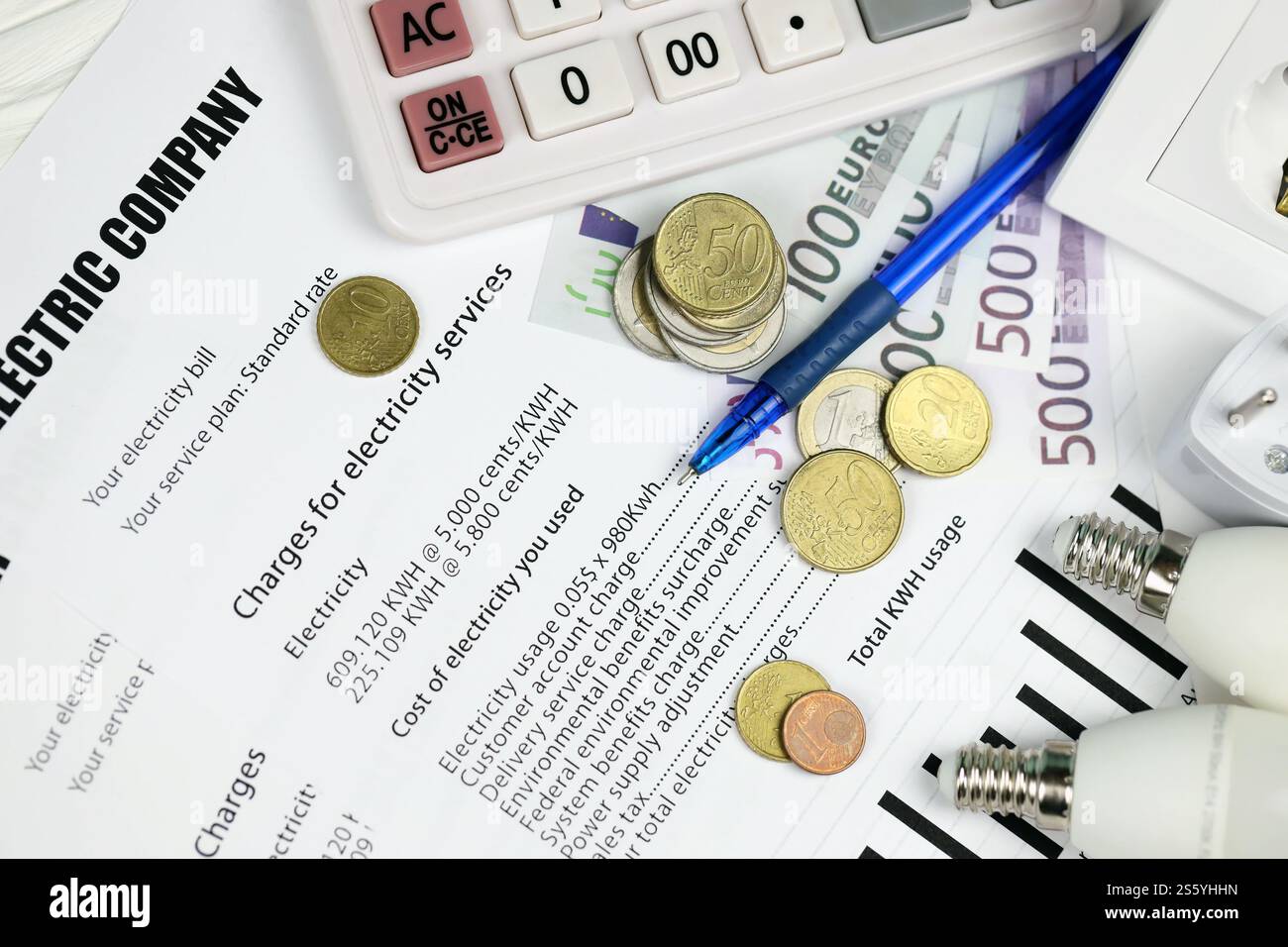 Calcolatrice e bollette Euro con penna sulla bolletta europea dell'elettricità. Concetto di risparmio economico utilizzando lampadine a LED a risparmio energetico e bolletta elettrica Foto Stock