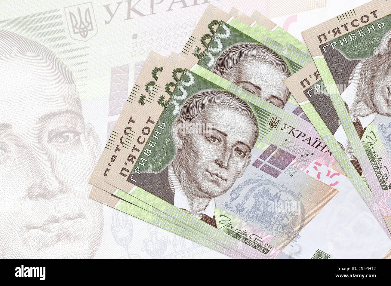 500 banconote ucraine in hryvnias si trovano in una pila sullo sfondo di una grande banconota semi-trasparente. Presentazione astratta della moneta nazionale. Affari Foto Stock