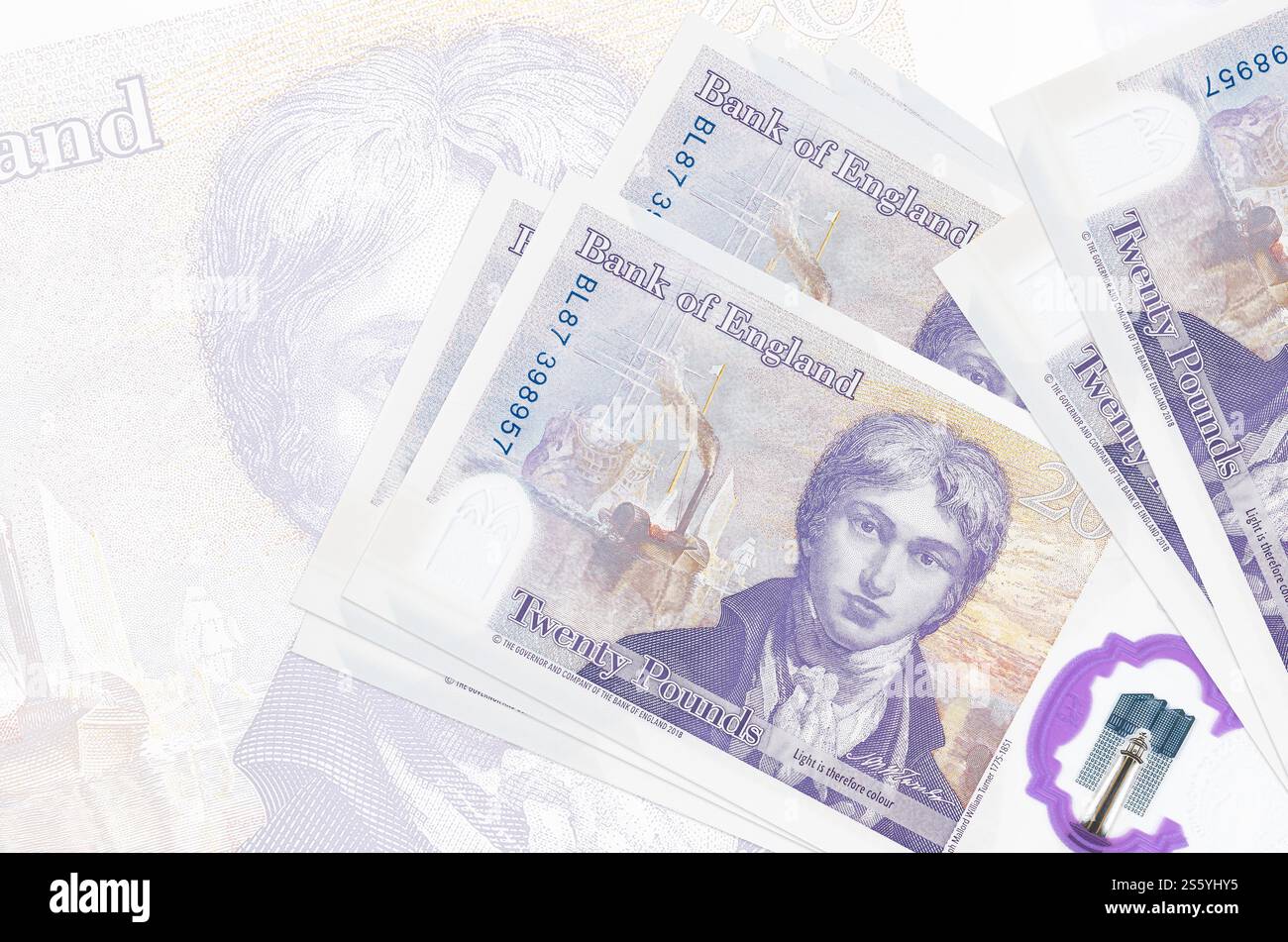 Le banconote da 20 sterline britanniche sono in pila sullo sfondo di grandi banconote semitrasparenti. Presentazione astratta della moneta nazionale. Concetto di business. Foto Stock