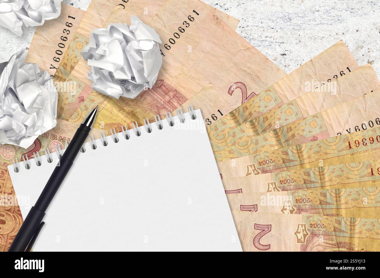 2 banconote e palle di hryvnias ucraine di carta stropicciata con blocco note. Idee cattive o meno di concetto di ispirazione. Alla ricerca di idee per l'investimento. 2 Foto Stock