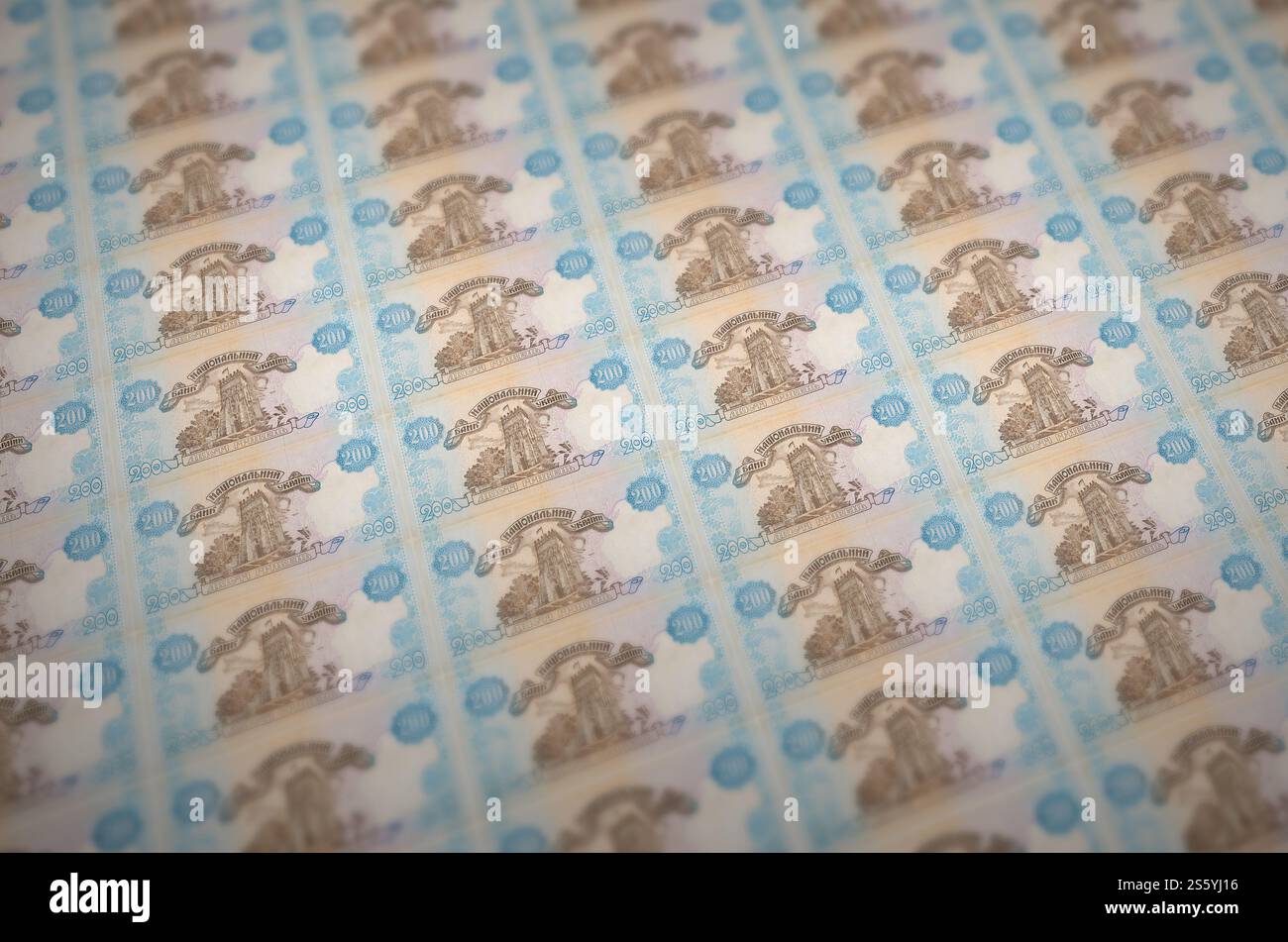 200 banconote ucraine di hryvnias stampate in un trasportatore di produzione di denaro illegale. Collage di molte banconote false. Concetto di lavoro di massa dei contraffattori. 200 Foto Stock