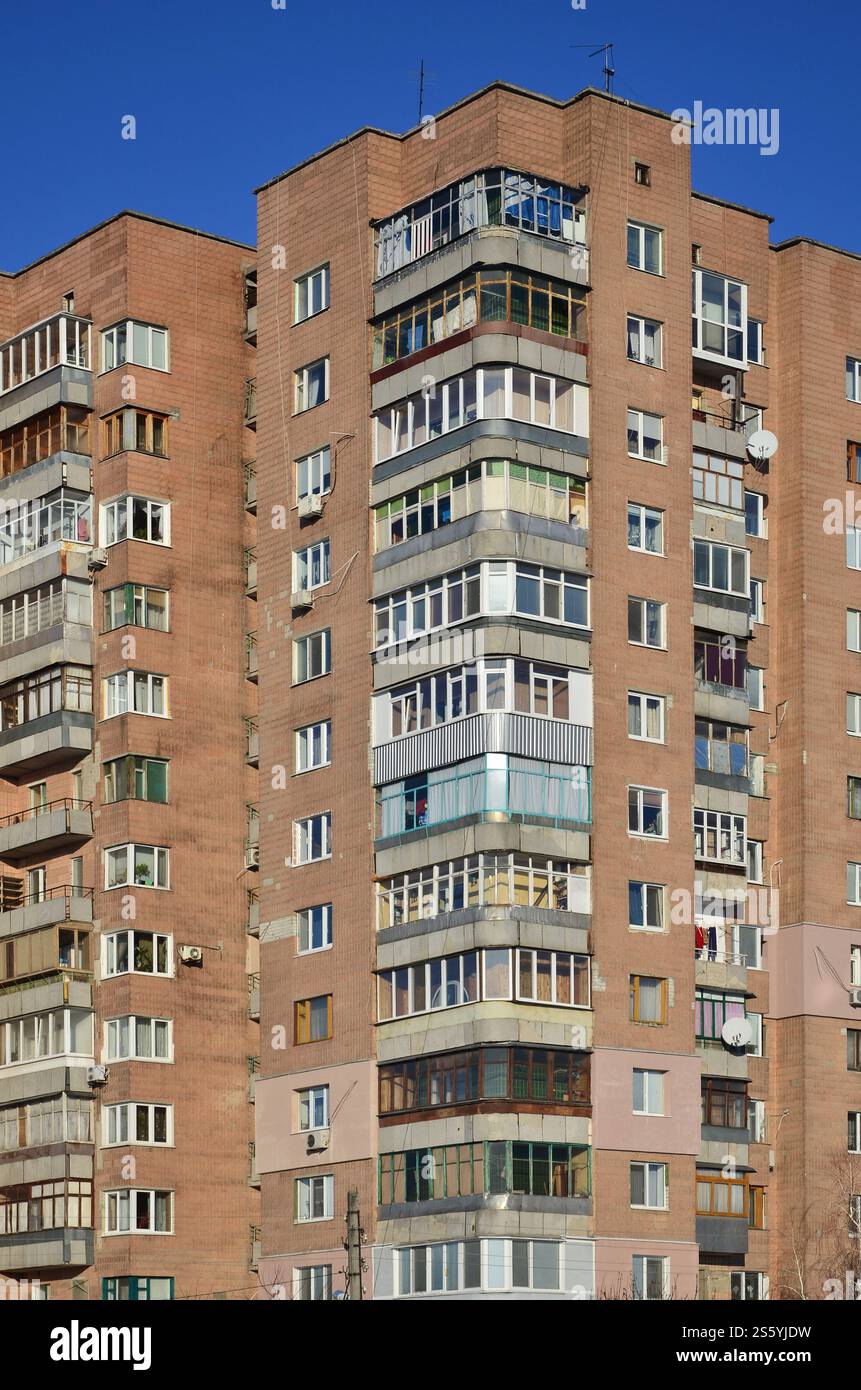 Foto dettagliate di un edificio residenziale a più piani con molti balconi e finestre. Ostelli per poveri in Russia e Ucraina in un danneggiato Foto Stock