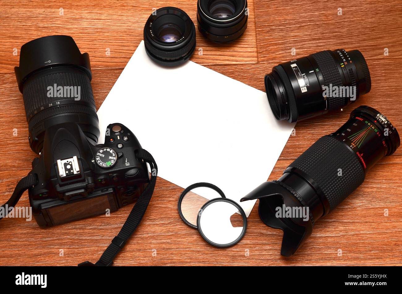STILL Life con un set di fotografi professionisti. Fotocamera con molti obiettivi e accessori fotografici su una superficie in legno marrone con un sito per Foto Stock