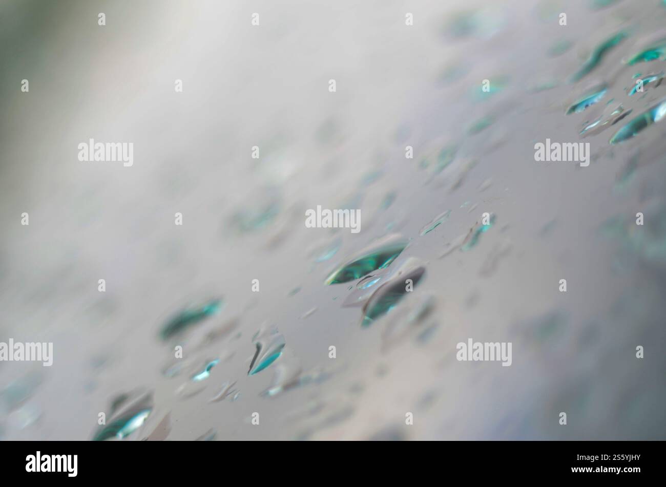 Acqua di piccole gocce di pioggia sul vetro blu nella macro. Natura astratta sfondo Foto Stock