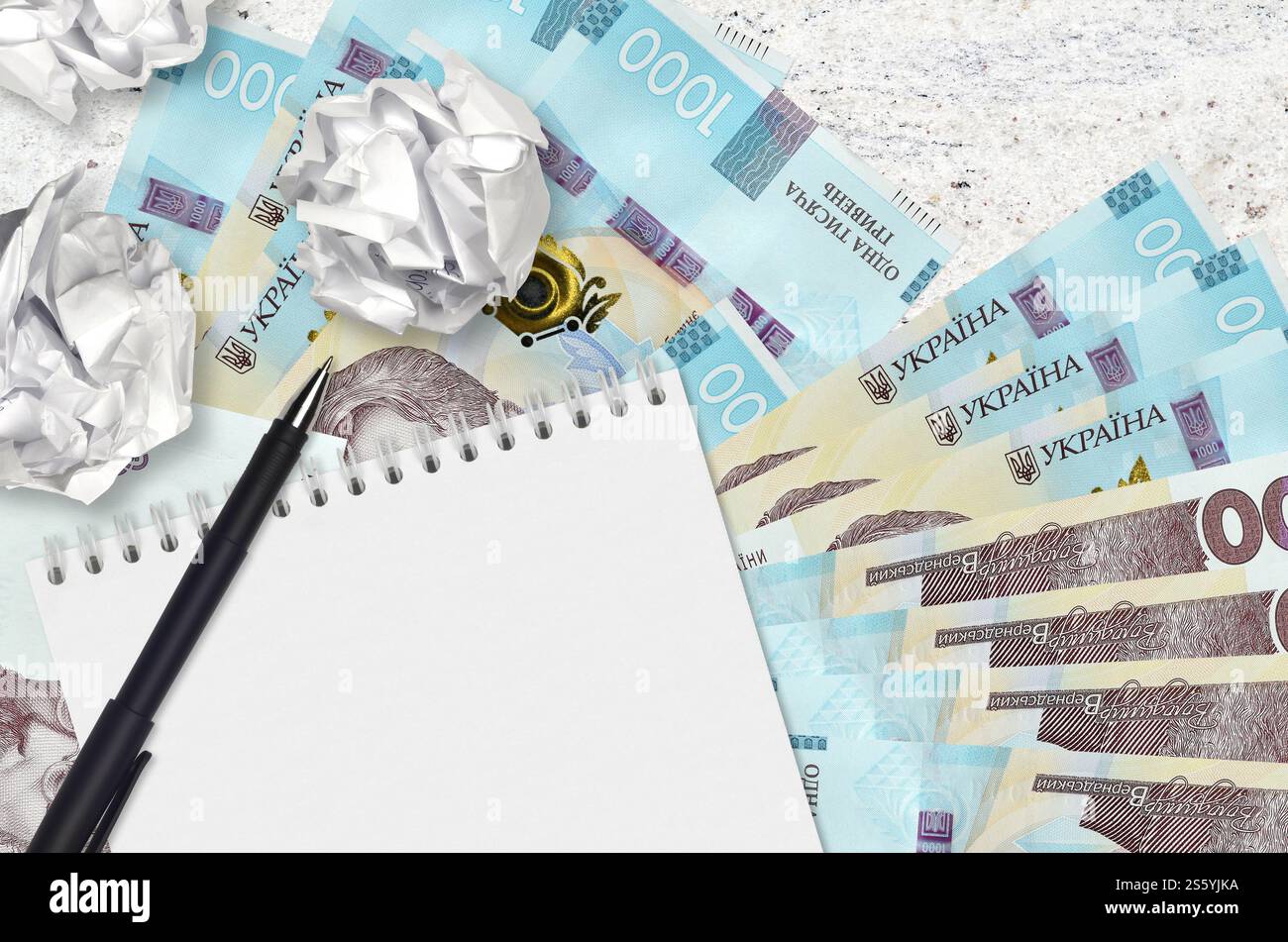 1000 hryvnias ucraine banconote e palle di carta stropicciata con blocco note. Idee cattive o meno di concetto di ispirazione. Alla ricerca di idee per l'investimento. Foto Stock