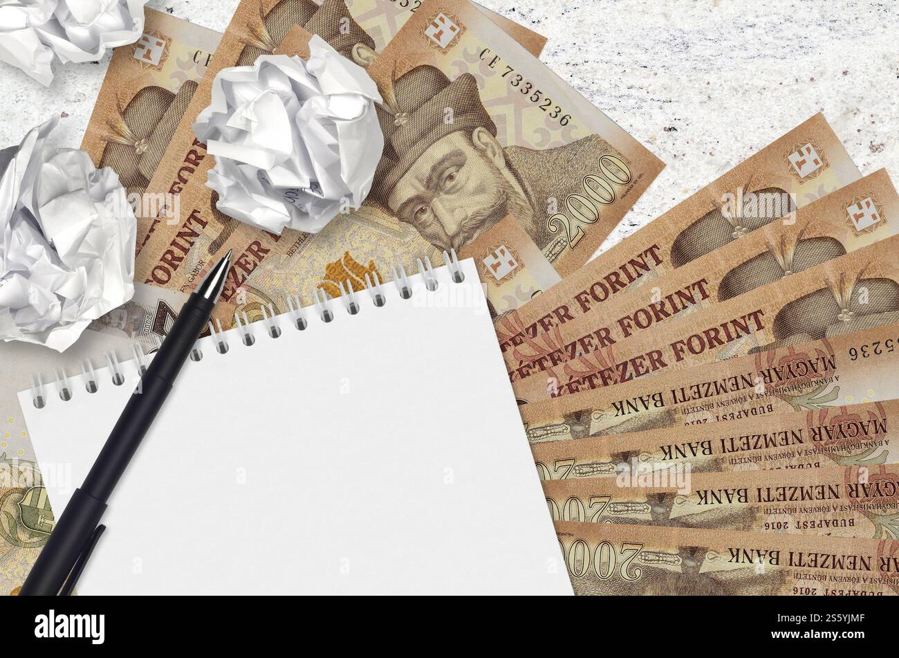 2000 banconote ungheresi e palle di carta increspata con blocco note. Idee cattive o meno di concetto di ispirazione. Alla ricerca di idee per l'investimento. 2000 Foto Stock