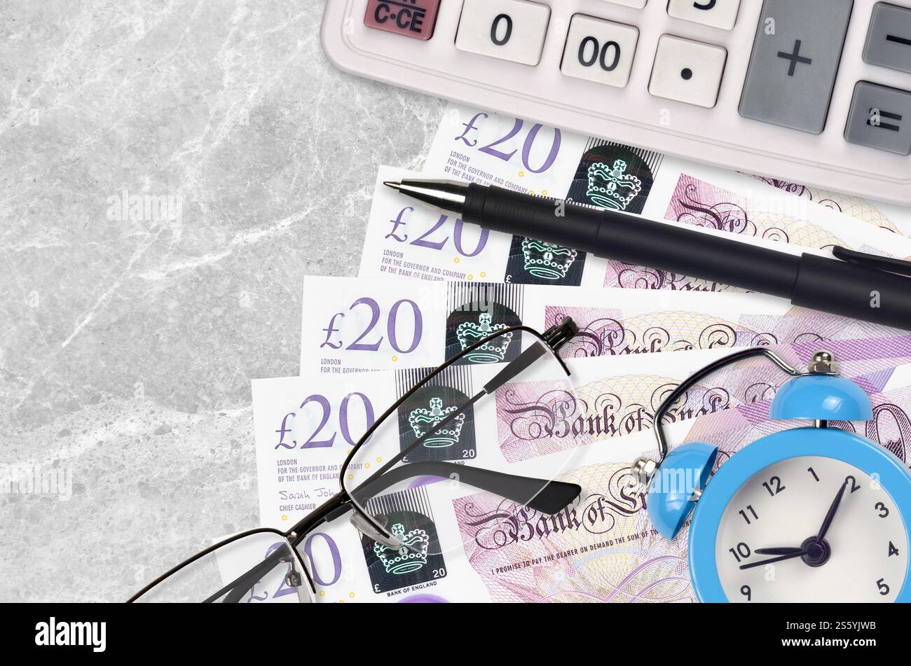Banconote da 20 sterline britanniche e calcolatrice con occhiali e penna. Concetto di stagione del prestito aziendale o del pagamento delle imposte. Pianificazione finanziaria e tempo per pagare le tasse. Foto Stock