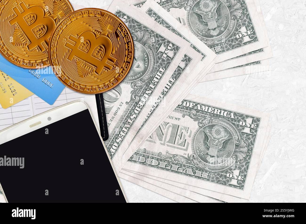 Banconote da 1 dollaro USA e bitcoin dorati con smartphone e carte di credito. Concetto di investimento in criptovaluta. Transazioni di mining o trading di criptovalute. 1 Foto Stock