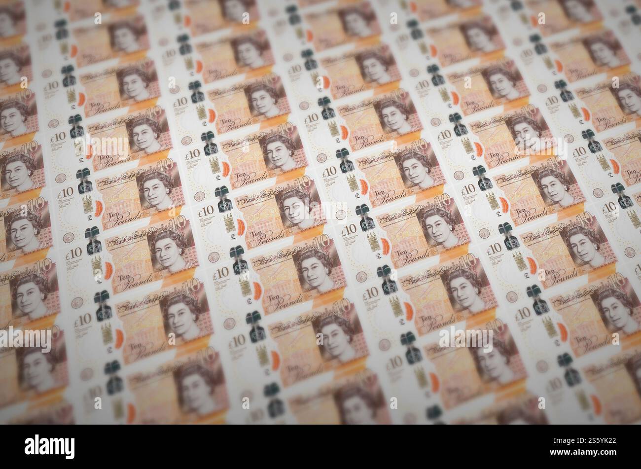Banconote da 10 sterline britanniche stampate su un trasportatore per la produzione di denaro illegale. Collage di molte banconote false. Concetto di lavoro di massa dei contraffattori. 10 inglesi Foto Stock