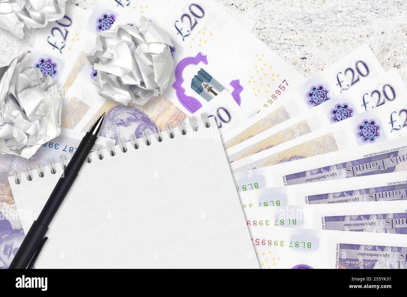 Banconote da 20 sterline britanniche e palle di carta stropicciata con blocco note. Idee cattive o meno di concetto di ispirazione. Alla ricerca di idee per l'investimento. 20 Foto Stock