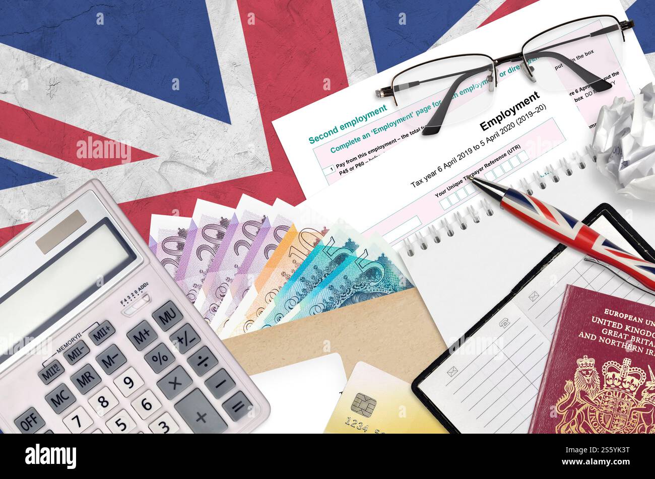 Modulo fiscale inglese sa102 l'impiego da parte di HM revenue and Customs si trova sul tavolo con gli articoli per ufficio. Documentazione HMRC e procedura di pagamento delle imposte nel Regno Unito Foto Stock