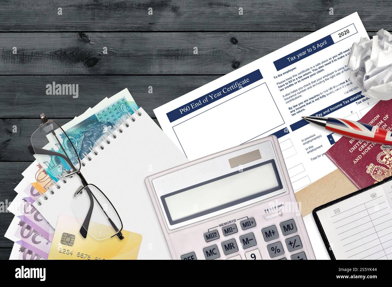 Modulo fiscale inglese P60 certificato di fine anno da HM Revenue and Customs si trova sul tavolo con gli articoli per ufficio. Documentazione HMRC e processo di pagamento delle imposte in Foto Stock