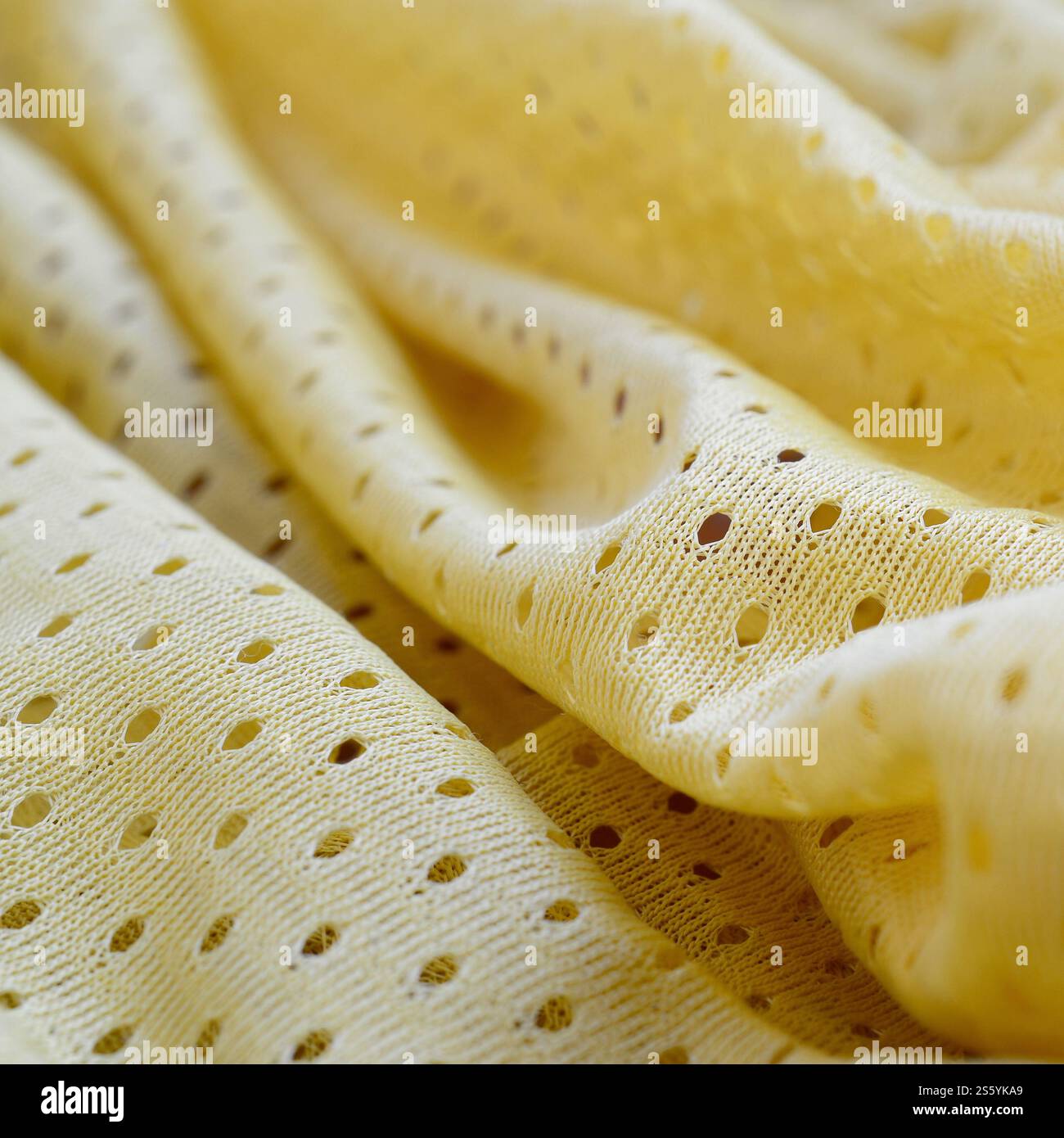 Sfondo in tessuto sportivo in rete gialla. Maglia da calcio colore giallo tessuto abbigliamento sportivo. Poroso traspirante Foto Stock