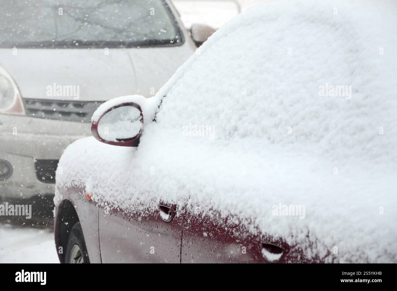 Frammenti di auto parcheggiate ricoperte di neve bianca. Frammenti di auto parcheggiate ricoperte di neve Foto Stock