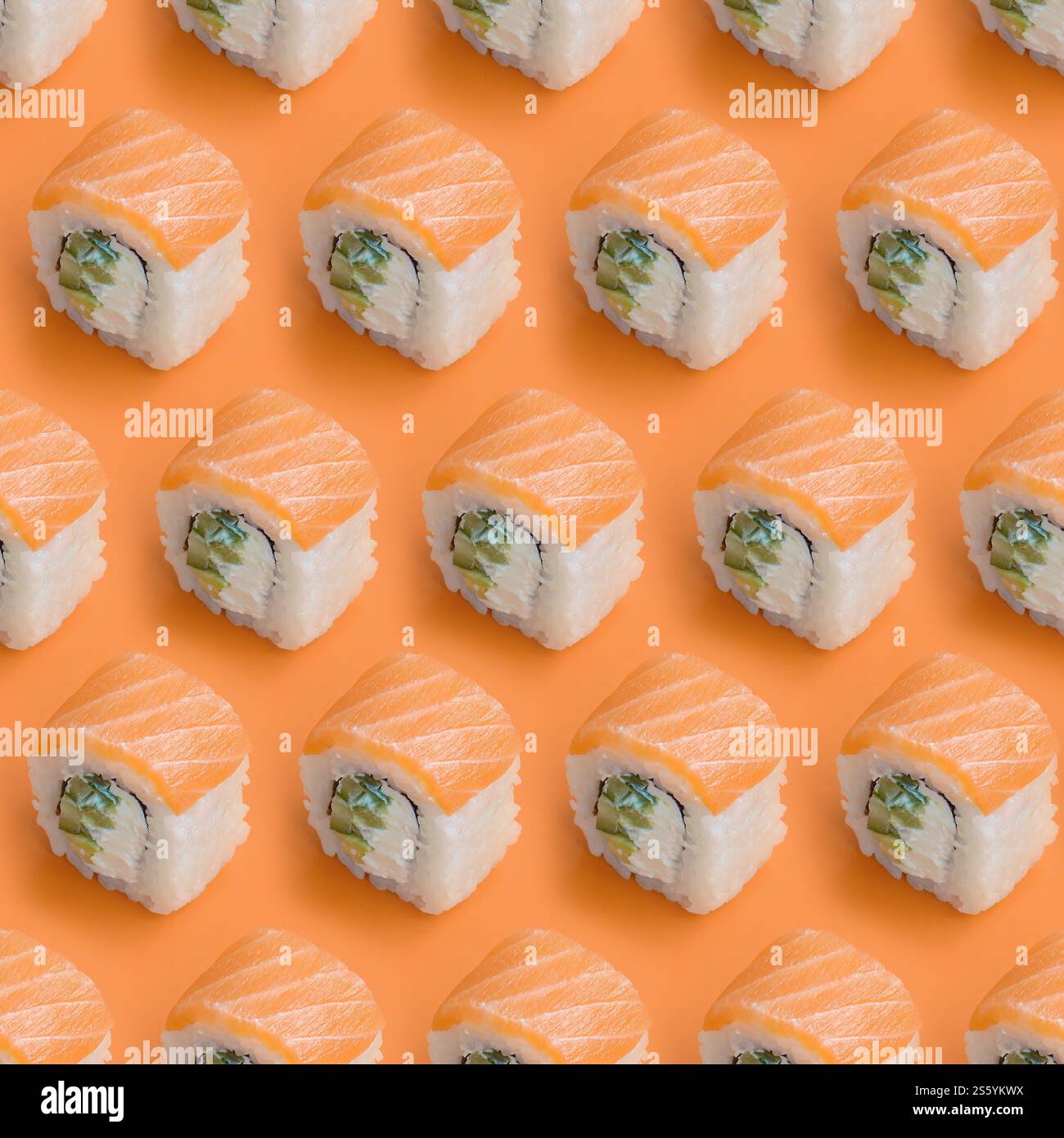 Involtini Philadelphia con salmone su sfondo arancione da vicino. Design minimalista con vista dall'alto e piatti giapponesi. Philadelphia Rolls con salmone Foto Stock