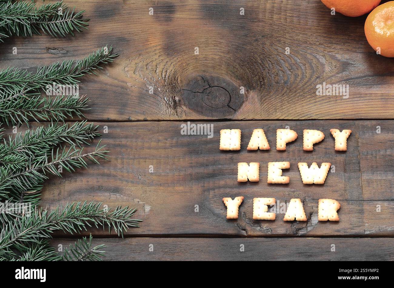 Biglietto natalizio con mandarini, testo cracker e rami di abete con spazio di copia. Vista dall'alto, disposizione piatta. Tangerini, testo cracker e rami di abete Foto Stock
