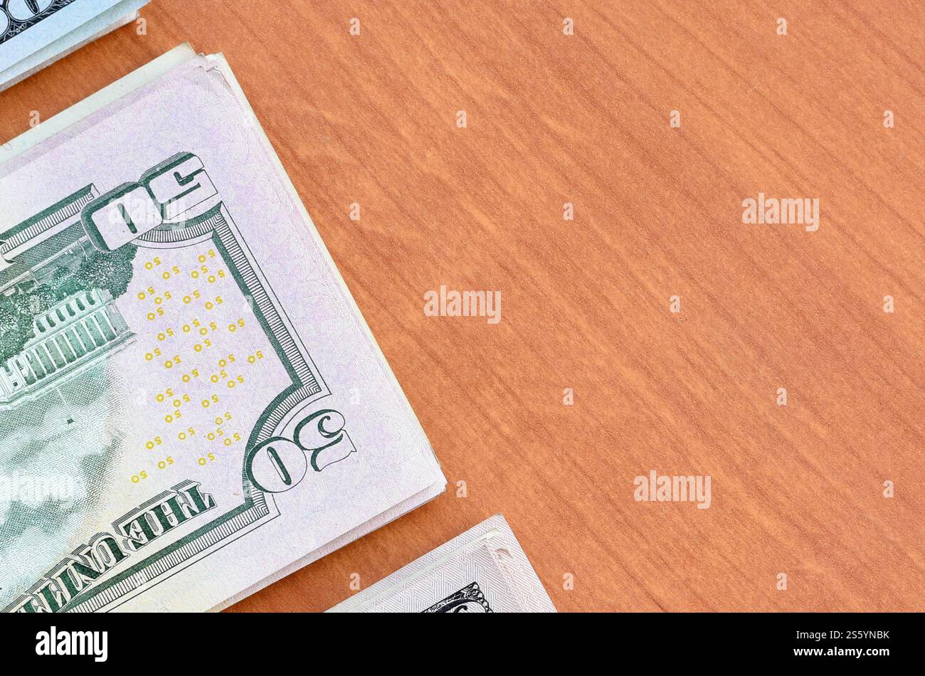 Pile di banconote da centocinquanta dollari su fondo in legno da vicino. Vista dall'alto in posizione piatta. Concetto di successo astratto o di business. Foto Stock