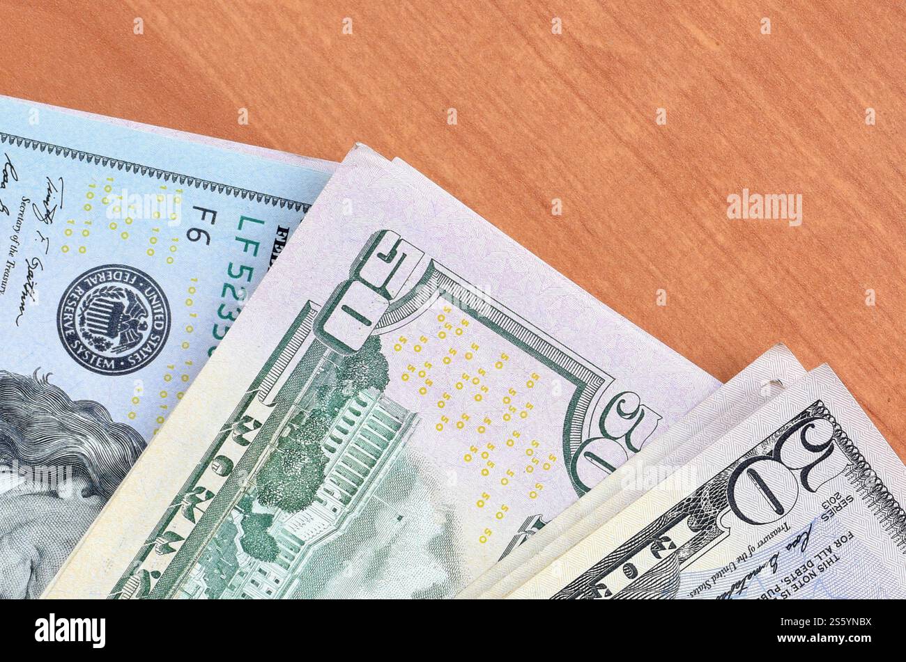 Pile di banconote da centocinquanta dollari su fondo in legno da vicino. Vista dall'alto in posizione piatta. Concetto di successo astratto o di business. Foto Stock