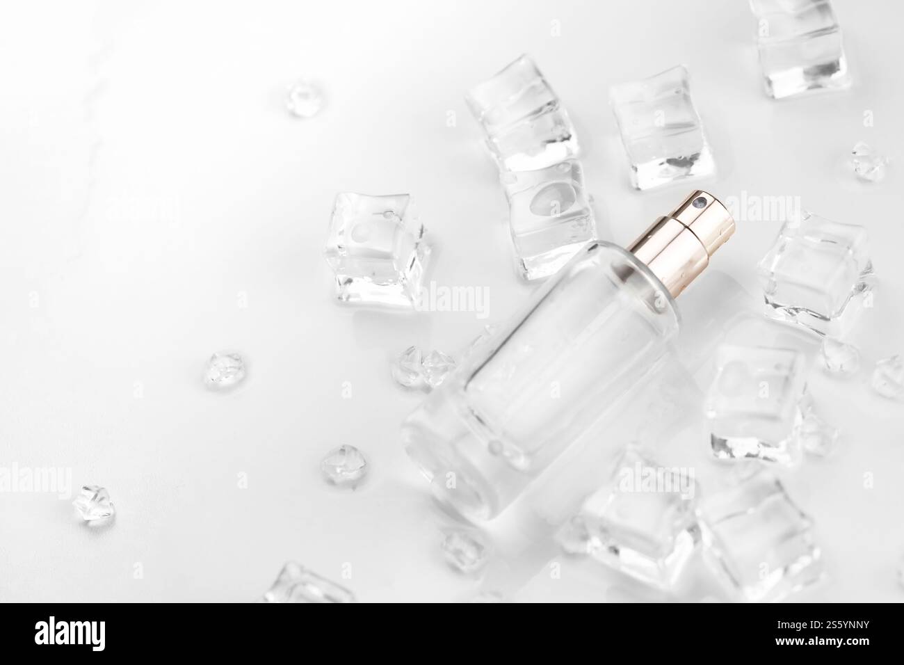 Bottiglia di profumo femminile, fotografia oggettiva della bottiglia di profumo in cubetti di ghiaccio e acqua. vista dall'alto. foto del prodotto, concetto di freschezza e aroma. Foto Stock