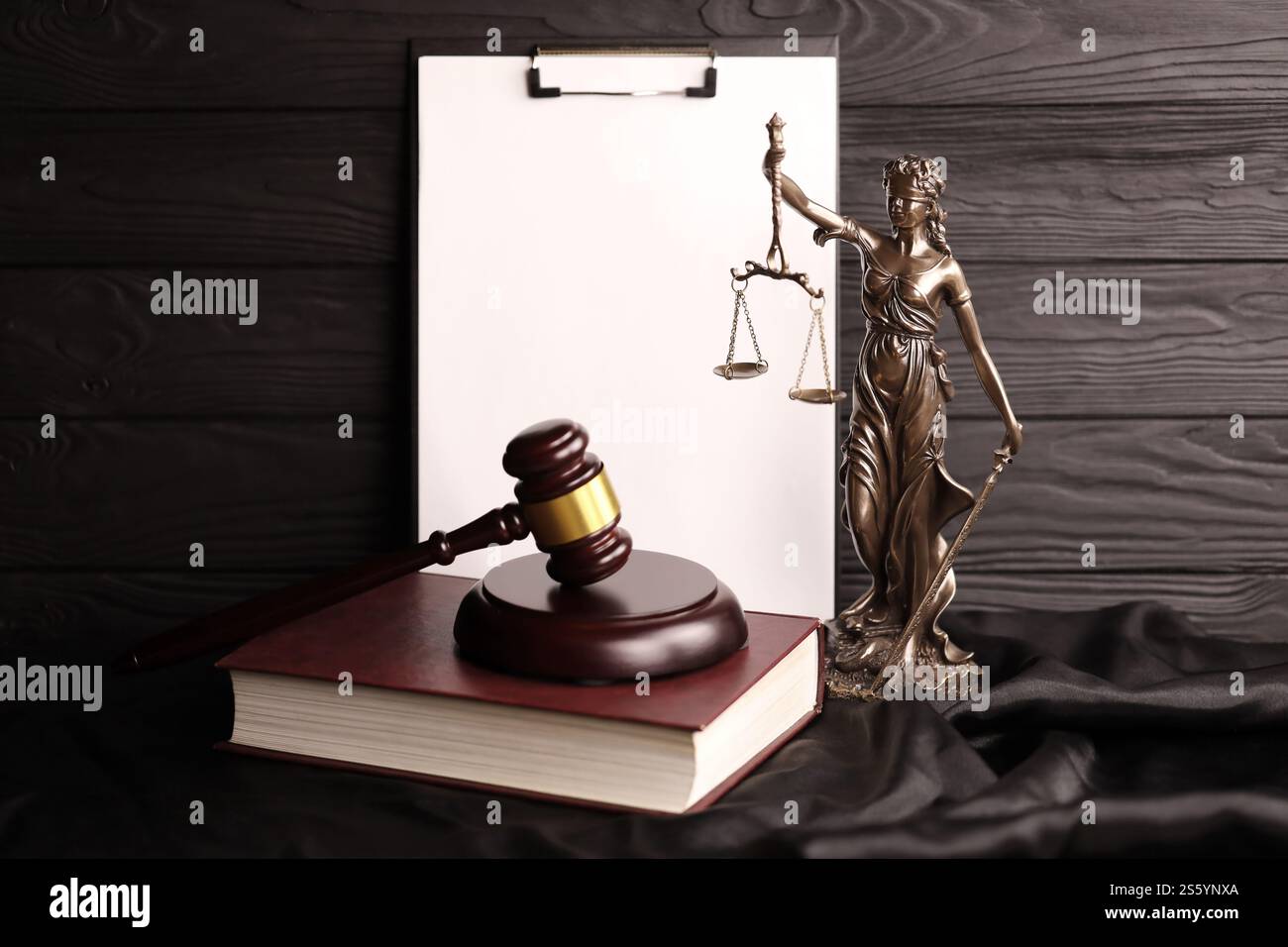 Lady Justice o justitia la dea romana della giustizia. Statua su libro marrone con martelletto giudice su sfondo di carta bianca con spazio per le copie. Concetto di Foto Stock