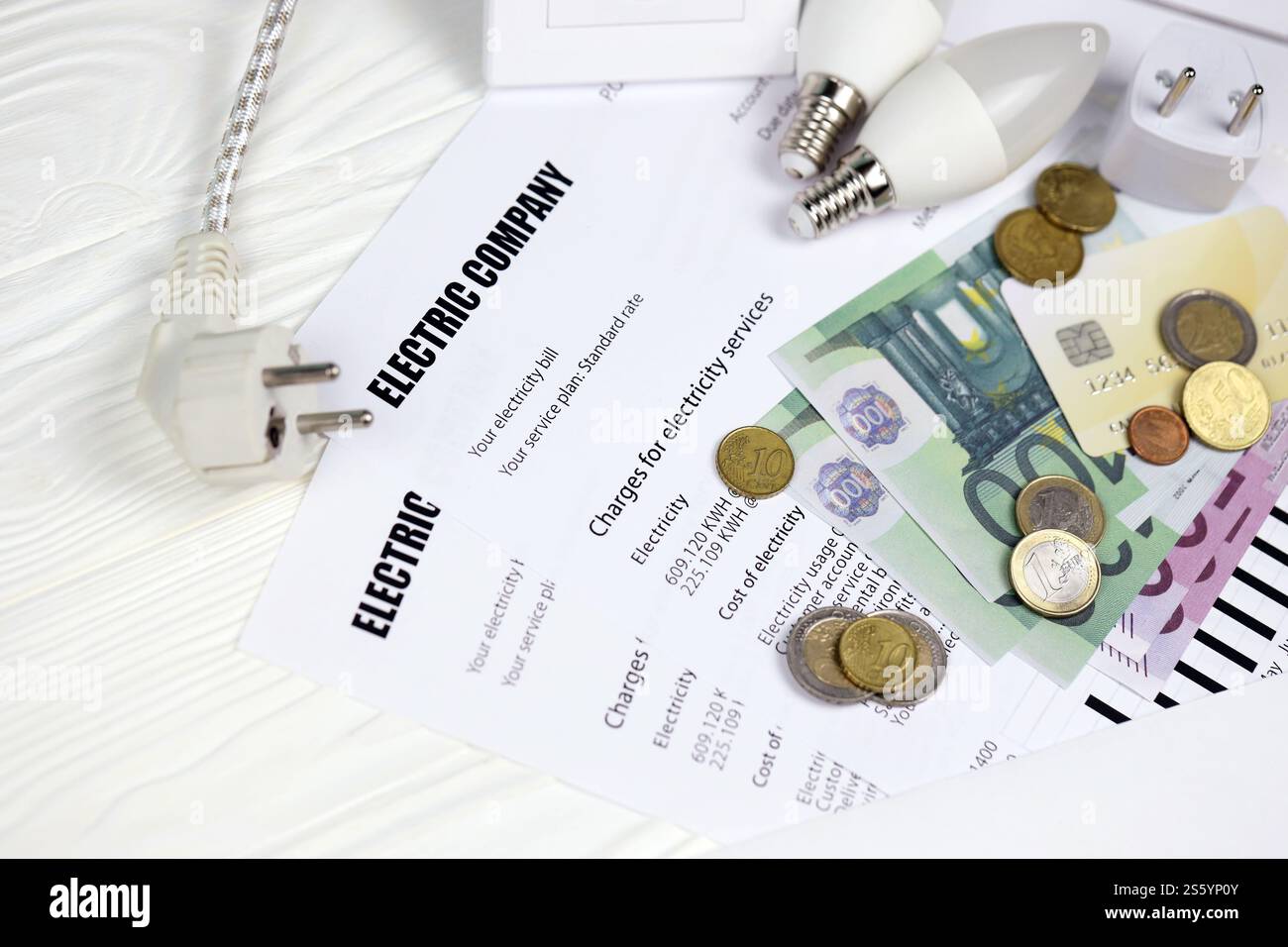 Calcolatrice e bollette Euro con penna sulla bolletta europea dell'elettricità. Concetto di risparmio economico utilizzando lampadine a LED a risparmio energetico e bolletta elettrica Foto Stock